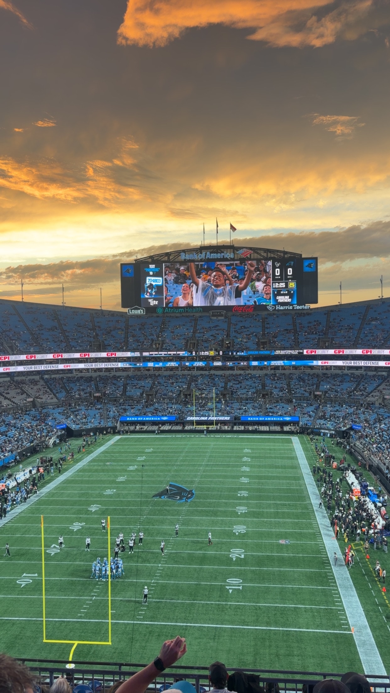 A football game at sunset, seen from the upper deck of the stadium