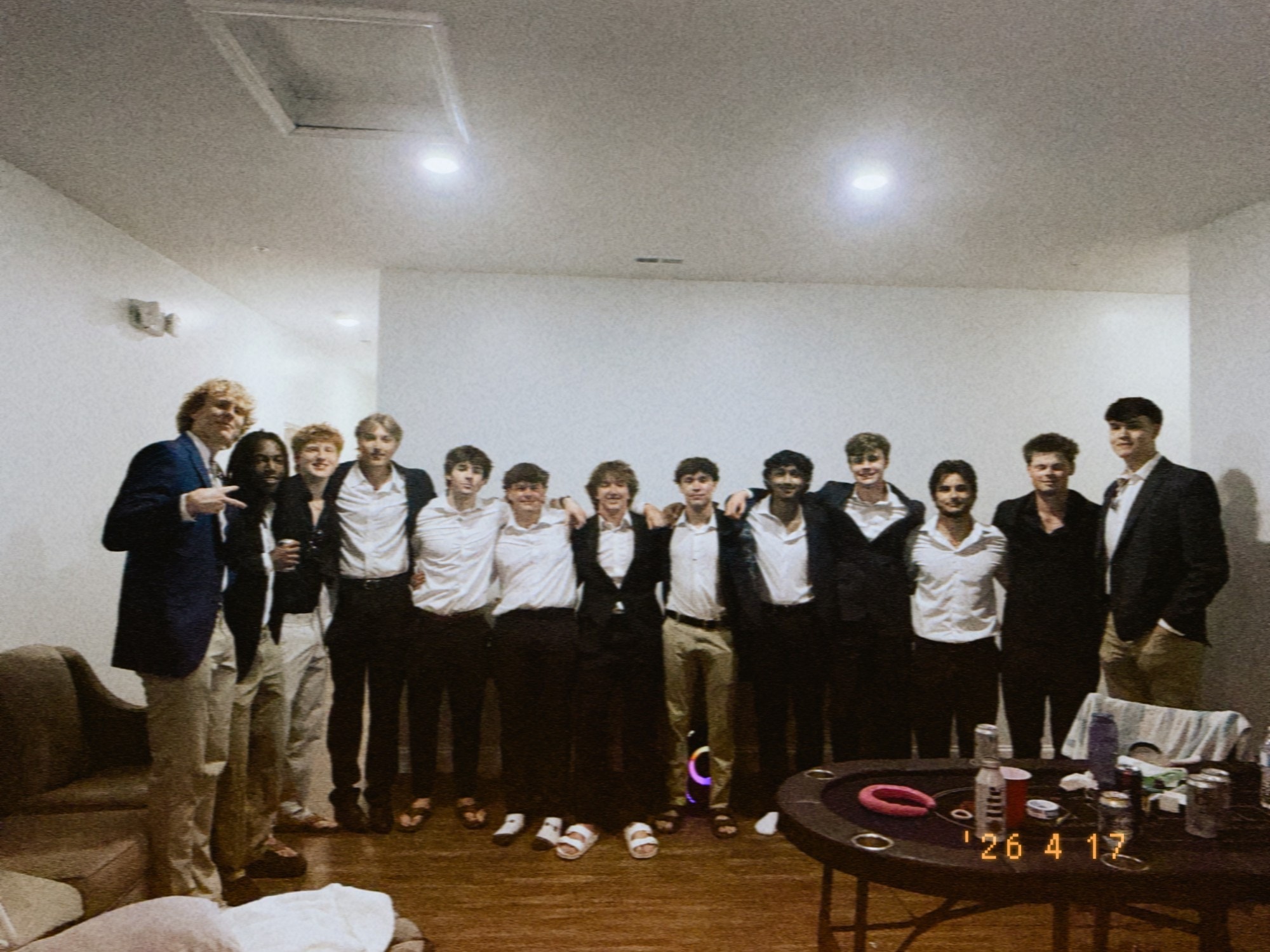 Thirteen brothers in blazers and white shirts standing arm in arm