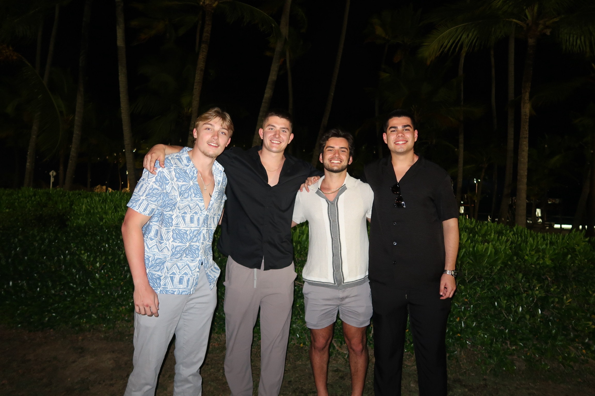 Four brothers dressed up for an evening out among palm trees
