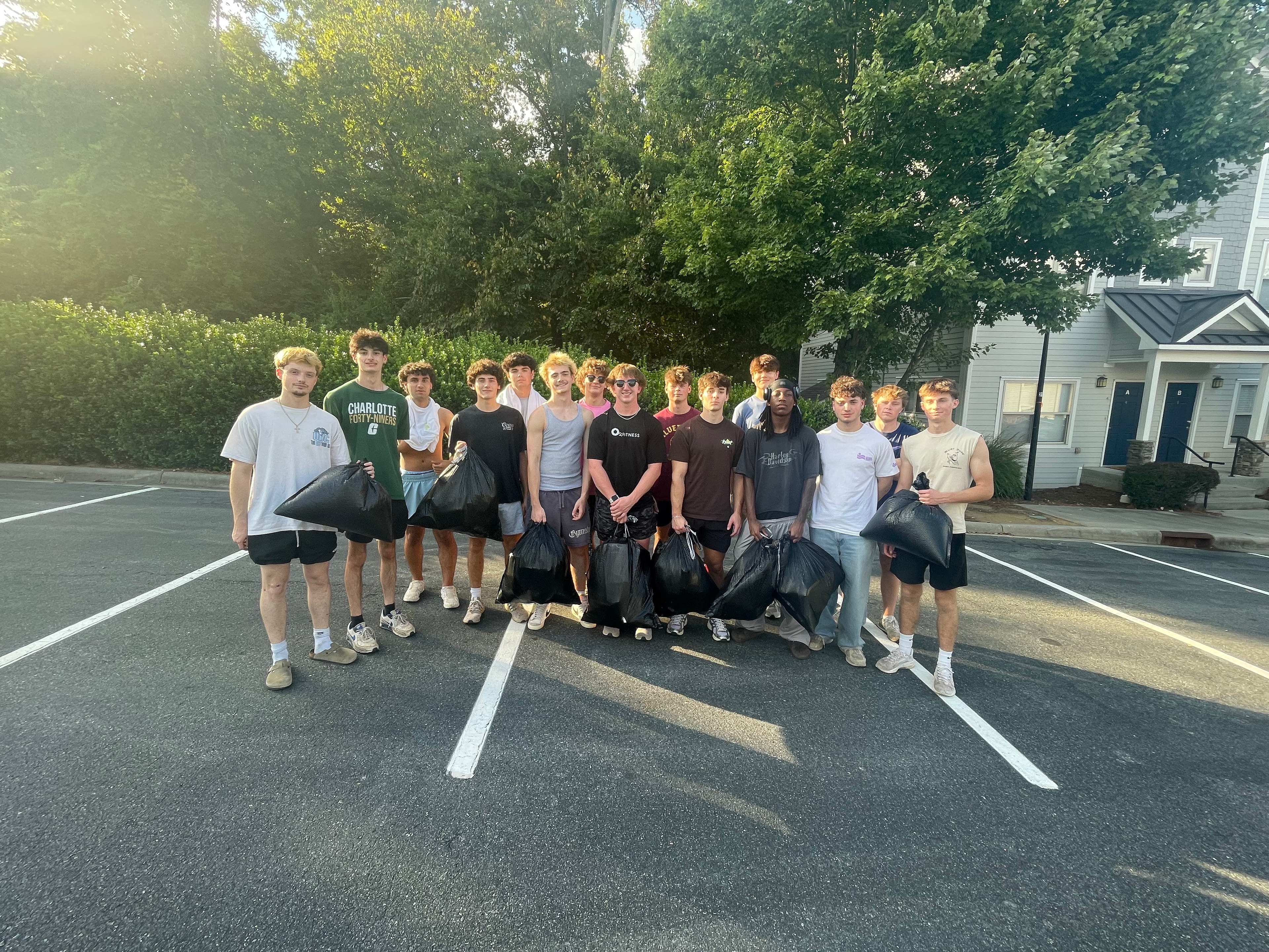 Brothers holding filled trash bags after a cleanup