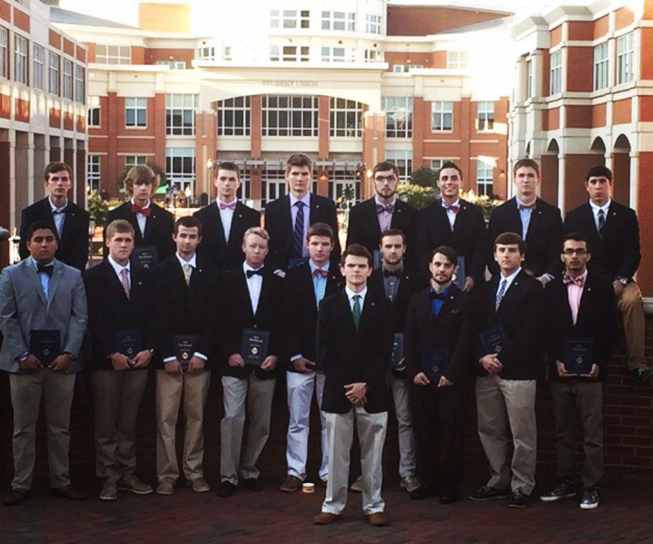 NC Epsilon brothers in blazers and bow ties posed in two rows in front of the Student Union